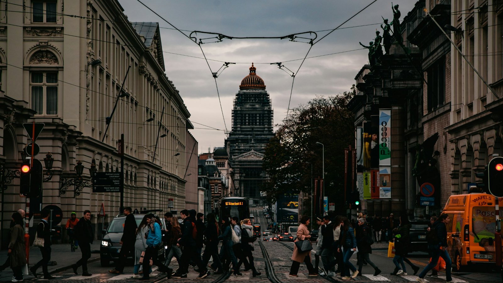 Busy city street with pedestrians and historic buildings in the evening