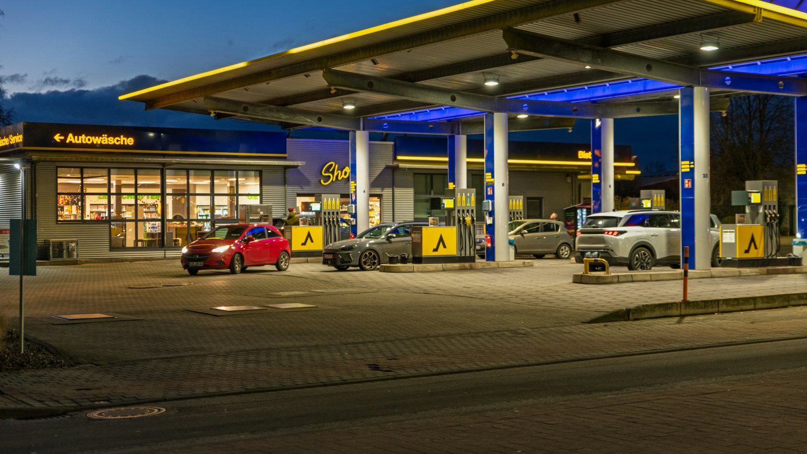 Petrol station canopy and cars at dusk
