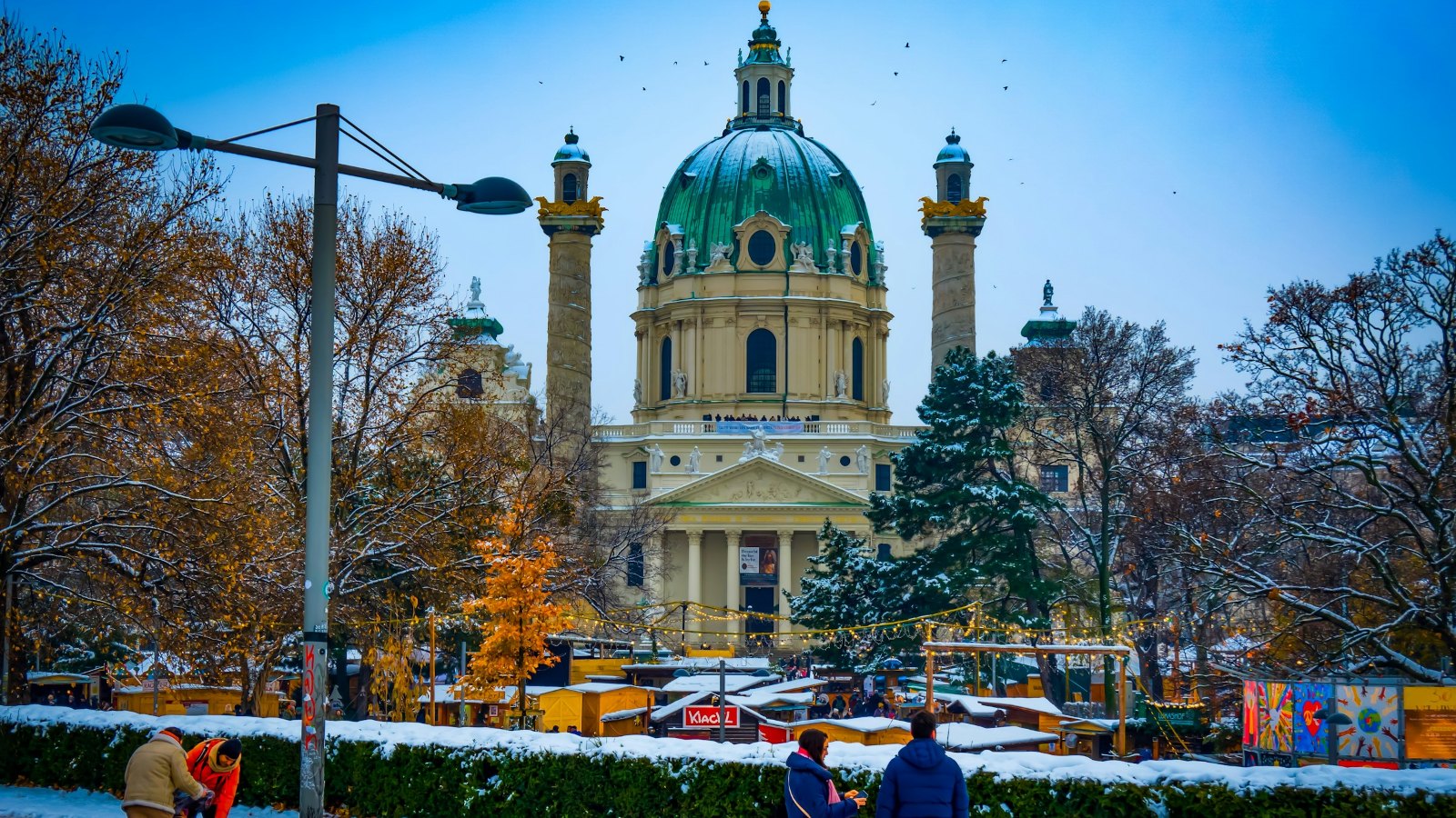 Karlskirche in Vienna with snow and a winter market